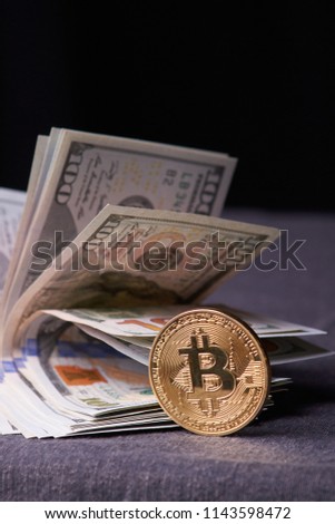 Golden metal bitcoin on dollar bills background. a lot of money in cash. 100 dollars texture. dear bitcoin. Gold coin. Profit from mining. Earnings on the growth of cryptocurrencies