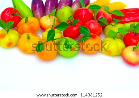 Thai native colorful candy made in fruit shape named "Look Choop", which mean glazing fruit shape in white isolated background with blank space. Thai cuisine food decoration concept.