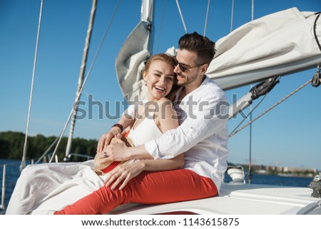 Beautiful, loving couple on a yacht in the summer sea. Sunny day. Yacht