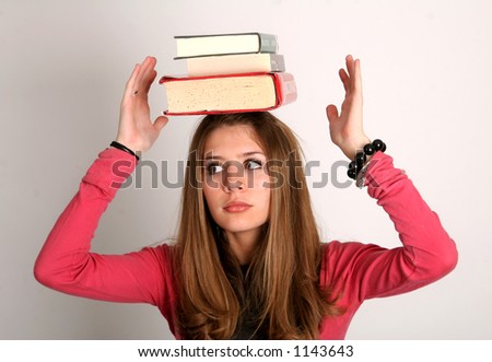 College-age woman balancing books on her head.