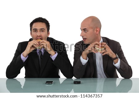 Businessmen eating burgers