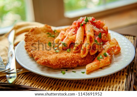 German chicken schnitzel with penne in red tomato sauce Royalty-Free Stock Photo #1143691952