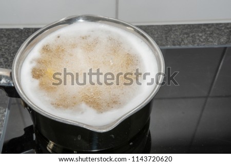 Boiling water in pan with bubbles in kitchen 