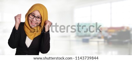 Portrait of success beautiful muslim businesswoman wearing hijab and eyeglasses winning victory gesture, web banner
