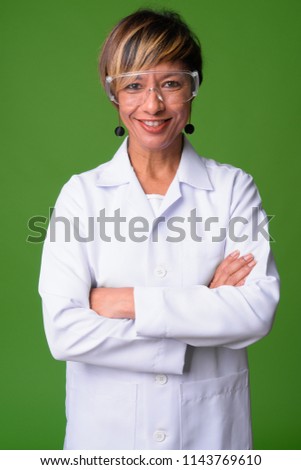 Mature beautiful multi-ethnic woman doctor wearing protective glasses