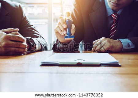 Young business man appoval stamper stamp on paper business contract. car loan money approved. Royalty-Free Stock Photo #1143778352