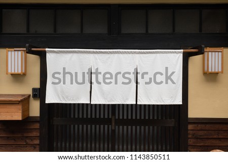 The curtain-like fabric that hangs in front of traditional Japanese restaurants and shops not only serves as a signboard, but holds a larger meaning, Royalty-Free Stock Photo #1143850511