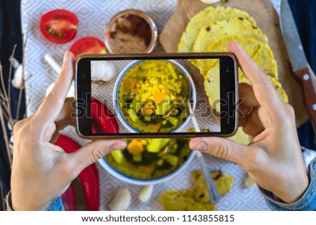Woman hands make photography of food with phone. Corn soup with vegetables. Smartphone photo of lunch for social media or blogging. Raw vegan vegetarian healthy food