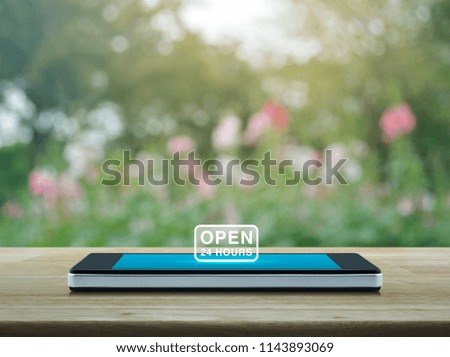 Open 24 hours icon on modern smart phone screen on wooden table over blur pink flower and tree, Business full time service concept