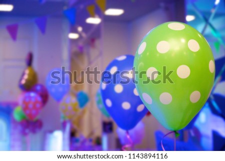 Balloons of bright blue and green colors with white spots as a decoration for a children's party.