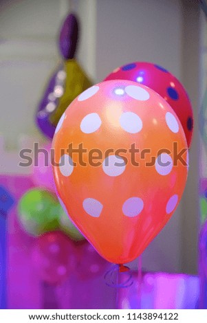 The balloon is bright orange with white spots as decoration on children's party.