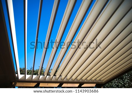 Wide angle shoot of outdoor grey windows aluminium louver shutter at the house back yard sun room with blue sky back ground  Royalty-Free Stock Photo #1143903686