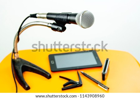 The microphone on the table wooden yellow.