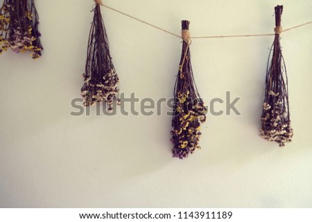 bouquet of dried flowers hanging on rope against wooden, decor wall backgrounde