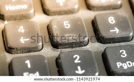 Close up photo of keyboard number button. Royalty high-quality free stock image of key number button on black keyboard with dust