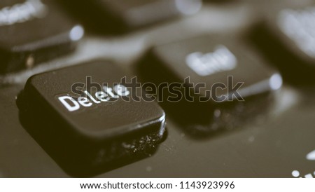 Close up photo of keyboard delete button. Royalty high-quality free stock image of key delete button on black keyboard with dust