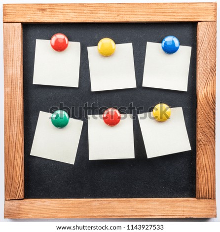 Blackboard and sticky notes stuck with colorful magnets. White background.