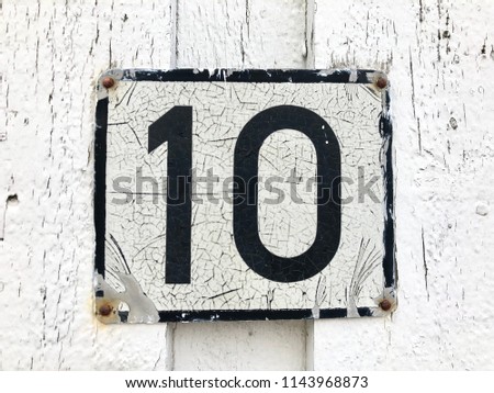 Vintage house number 10 metal sign in black and white