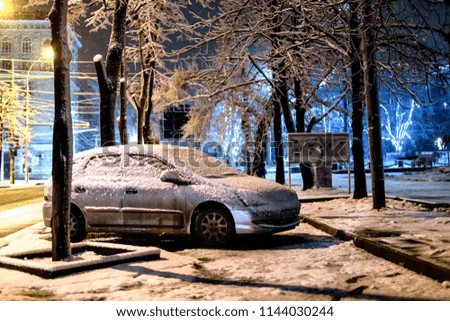 snow-covered car in winter car parking