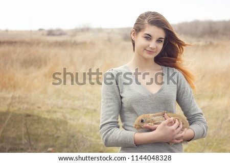 the girl with the rabbit.happy little girl holding cute fluffy Bunny.Friendship with Easter Bunny. Spring photo with beautiful young girl with her Bunny. Girl is holding a cute little rabbit