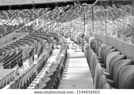 Background of empty red stadium chairs in a row. Black and white