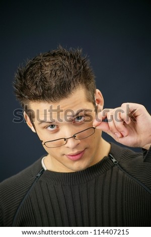 Young man removing his eyeglasses