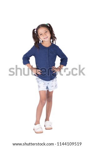 Full-length shot of a lovely little girl wearing a casual outfit, putting hands on waist, isolated on a white background