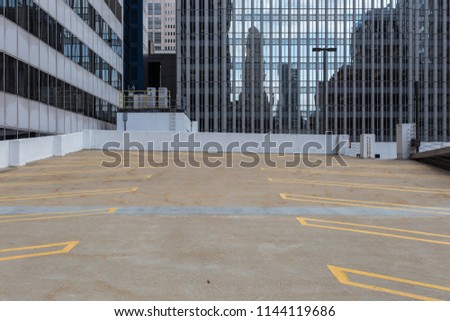 Empty parking lot surrounded by large office buildings