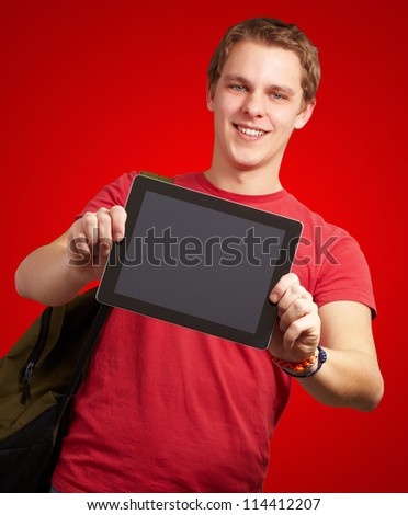 portrait of young man holding a digital tablet over red background