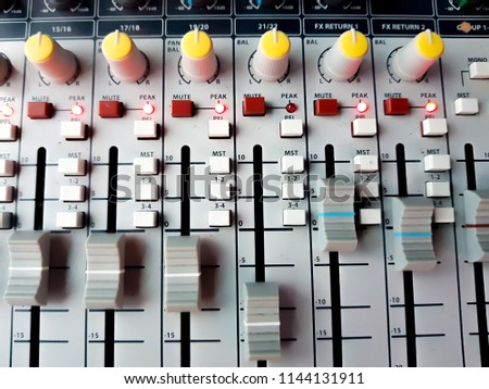 Vintage sound or audio mixer in a recording studio. Knobs, dials and sliders on a soundboard