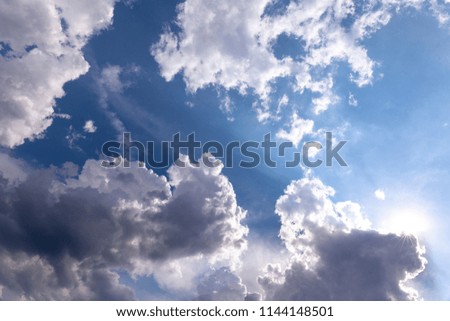 cloudscape with blue sky and bright shining sun