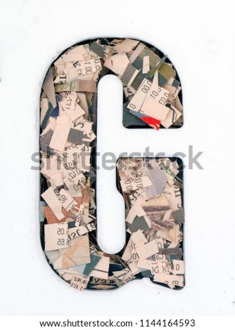financial news  newspaper cut up into confetti  to make  the captal letter G