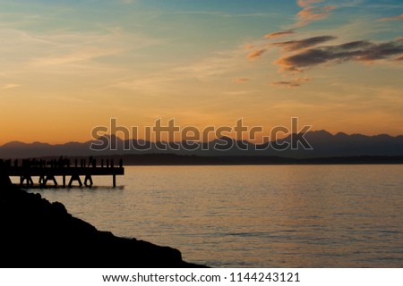 Sunset at Anchor Park in West Seattle, Washington. On a warm summer evening people flock to Alki Beach and Anchor Park for beautiful sunset views. 