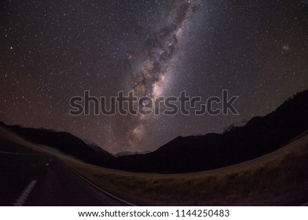 Milky Way Galaxy shot right in the middle of a road. There are millions of stars in the night sky. It is amazing to look at. The milky way galaxy center is bright.