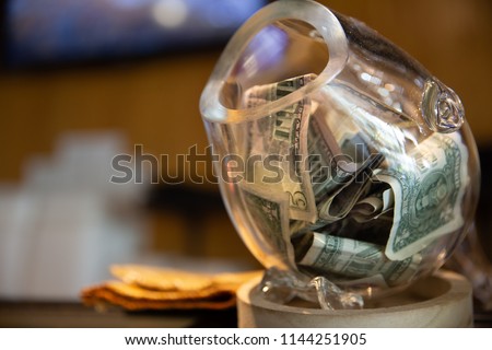 Tip Jar with Money in it and Space for words Royalty-Free Stock Photo #1144251905