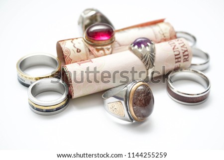 rings and Saudi Riyals bank notes with makkah , medina , riyadh landmarks. Coins designed to show religious tourism supporting financial investment opportunities