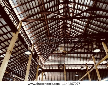 Internal wooden roof structure. The construction of a large internal building of a wooden roof with beams and light windows.