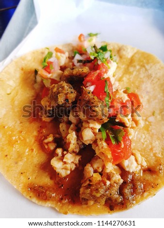 Taco beef, tomato and onion on a Mexican tortilla.