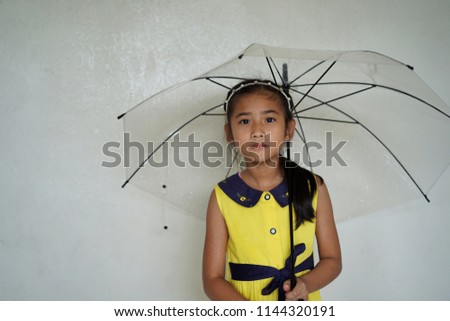 Portrait Asian cute little girl hold Umbrella when Rain