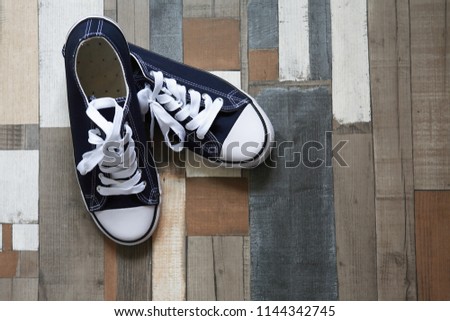 Pair of keds on color wooden background with free space