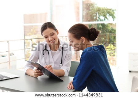 Young doctor consulting patient in modern hospital Royalty-Free Stock Photo #1144349831