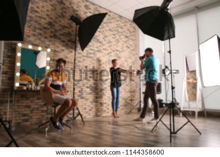 Blurred view of professional team working with model in photo studio