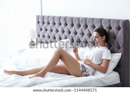 Young woman with pregnancy test in bedroom. Gynecology