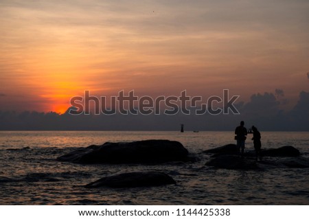 the man and women are preparing take a picture on beach at the sunrise time in morning with twilight sky, holiday and travel with copy space and sea view background