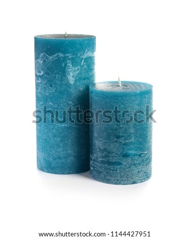 Two decorative blue wax candles on white background