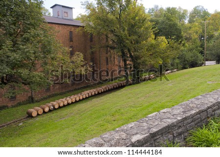 Whiskey or bourbon barrels at a distillery being moved after filling to warenhouse Royalty-Free Stock Photo #114444184