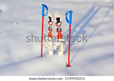 Funny children skis with clown picture on it , sticked in to white puffy snow