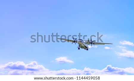 An ATR 72 turboprop regional airliner aircraft flying over blue sky with clouds Royalty-Free Stock Photo #1144459058