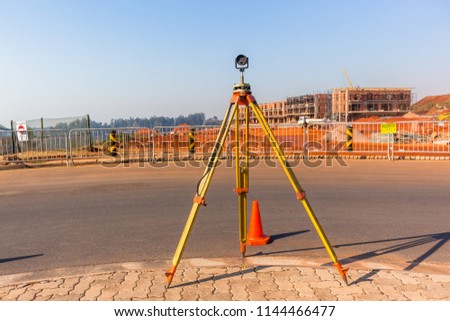 Construction building site landscape with land surveying tripod and measurement scope tool on roadside