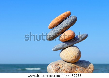 Unstable construction of multi-colored stones. The disturbed equilibrium. Imbalance concept. Royalty-Free Stock Photo #1144487756